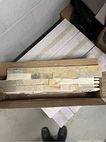 Open box showing stacked stone panels inside, view from above