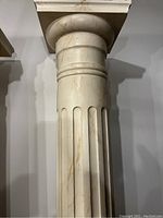 Full view of the tall, fluted pine pillar showing its cream/off-white color and vertical groove details.