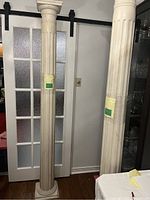 Full view of tall pine pillar/column with white painted fluted design in front of door.