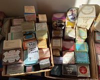 Overview of vintage Avon boxed cologne, perfume, and bath oil collection, showing multiple boxed items in a cardboard tray.