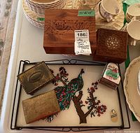 Photo showing the Jensen art glass tray with a colorful peacock on branch design along with five assorted jewellery boxes in metal and wood.