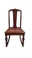 Front view of antique rocking chair showing cane seat and carved backrest