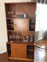 Front view of the two-piece hutch showing open top shelf, middle and lower sliding doors, assorted glassware removed in listing.