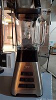 Full view of Oster blender showing glass pitcher and main body with control buttons and logo.