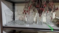 Shelf with five vases: three clear glass vases including two flared rim and one small round, plus two tall crystal cut glass vases with detailed patterns.