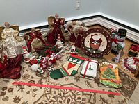 Full lot of Christmas decorations including angels, snowmen, plate, stocking, towels, wreaths, and basket arrangement on floor