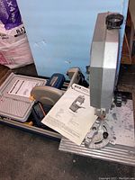 Bench top band saw BS-900 and smaller tile saw side by side with operating manuals on base