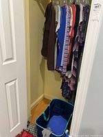 Photo showing a clothing rack loaded with various women's dresses, T-shirts, and tops mostly in size small.