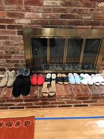 All ten pairs of women's shoes and boots displayed on brick hearth, including boots and various casual shoes, all size 8.