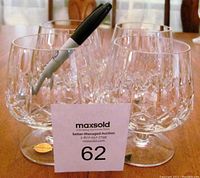 Four matching Hungarian hand cut lead crystal cognac snifter glasses arranged together showing original vintage stickers on base and intricate cut patterns.