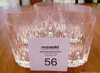 Five clear lead crystal scotch glasses arranged on a wooden surface with auction lot card in front.