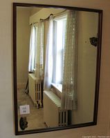 Front view of the rectangular teak wall mirror hanging on the wall, showing reflective glass and frame profile.