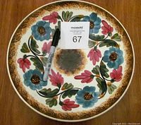 Top view of the handmade floral bowl with pen and lot number for scale.