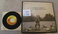 George Harrison's 'All Things Must Pass' 3 LP album cover with a sepia photo of George and garden gnomes outdoors, accompanied by The Beatles 7-inch single 'Twist And Shout' with original Capitol swirl label