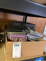 Box of assorted music CDs showing visible album David Bromberg and others stacked inside.