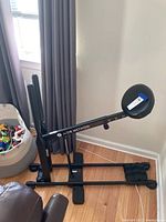 Side view of black DB Method squat exercise machine showing padded seat, frame and footrests.