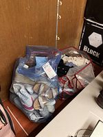 Two large plastic bags filled with folded women's sweaters, shirts and pants, showing assorted colors and fabrics.