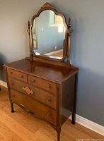 Full view of the antique oak Victorian dresser with swivel mirror showing carved wooden details, four drawers, and metal pulls.