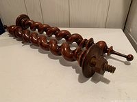 Pair of barley twist wood spindles with detailed view of wood grain and metal attachment