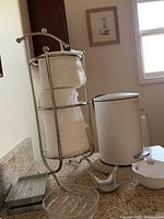 Mini waste bin, toilet paper holder with spare rolls, two soap dishes, and Umbra ring holder on a bathroom counter