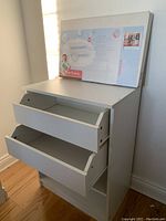 Assembled white drawer unit with three drawers, showing the drawer fronts open and the side panels.