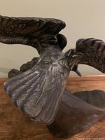 Close-up of the seagull's wing and body showing detailed feather texture and cold painted green patina.