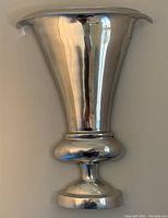 Front view of polished chrome hollow wall vase decor item showing its reflective metal surface, flared top, and rounded base.