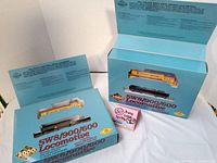 Lot showing two PROTO 2000 series HO scale locomotives in original blue packaging, one painted in Chessie System livery and one black locomotive.