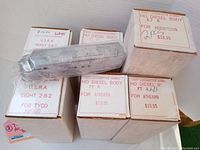 Six new old stock HO scale U.S.R.A diesel body shells in original boxes with price tags visible. Boxes labeled for Mantua, Tyco Mikado, Athearn and Hobbytown compatibility.