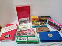 Lot of over 10 vintage model train cars and accessories in original packaging on display.
