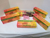 Six new old stock Roundhouse HO scale train car kits in original colorful boxes arranged on a white cloth.