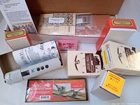 Top-down photo of the lot showing 8 boxes of new old stock HO train model kits including Highliners and Mac semi van trailer.