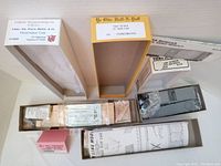 Top-down view of three boxed train kits showing labeled box tops and visible contents