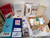 Photo showing the full lot of boxed and bagged HO scale model kits and parts arranged on a white cloth.