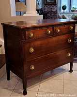Full view of the dresser showing the top and left side with wooden surface and four drawers.