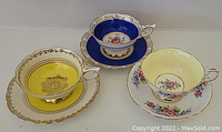 Three teacups and matching saucers arranged to show color and design variety