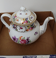 Front angle view of porcelain tea pot in cardboard box