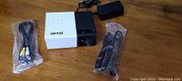 Front and top view of iWoly mini projector with power cable and AV cable