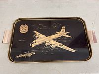 Full view of the rectangular metal serving tray showing aircraft illustration and naval ship with gold-tone trim and handles.