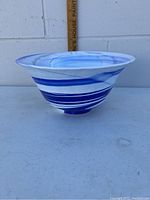 Side view showing blue and white swirling pattern and flared rim of the glass bowl.