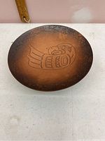 Top view of copper plate showing Haida-style etched bird design and patina.