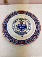 Top view of the Wedgwood china plate showing the University of Toronto emblem with crest and decorative border.
