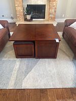 Front view of assembled coffee table with ottomans stowed beneath.