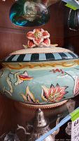 Fitz & Floyd large decorative bowl with lid featuring floral pattern and black-and-white striped rim with flower knob.