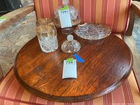 Top view of the wooden lazy Susan with glassware on top placed on a striped cushioned chair.