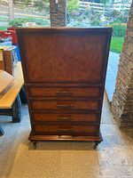 Front view of closed wooden liquor cabinet on caster wheels