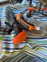 Ramset TriggerShot power tool with charger and other accessories on striped fabric
