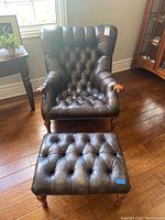 Front view of chair and ottoman set on hardwood floor