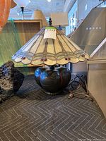 Full view of Tiffany inspired desk lamp with stained glass shade and dark base.