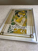 Framed litho print mirror showing full Art Nouveau design with woman and 'Nostalgia' text.